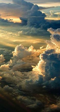 the sky is filled with lots of clouds and sun rays coming through them, as seen from an airplane window