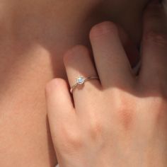 a woman's hand with a diamond ring on her left side, close up