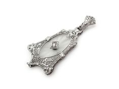 a silver brooch with an ornate design on it