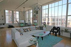 a living room filled with furniture and lots of windows