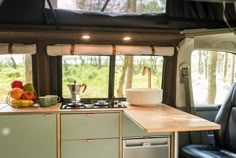 the interior of a camper with an oven and sink