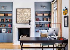 a living room filled with furniture and bookshelves next to a fire place in front of a fireplace