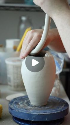 a person is working on a vase in the process of making something out of clay