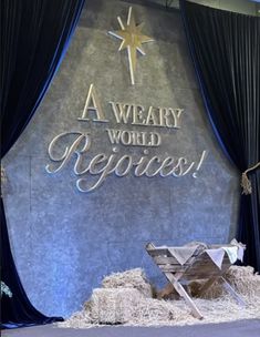 a stage set up with hay and a nativity scene in the background that says, a weary world rejoces