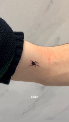 a small spider tattoo on the arm