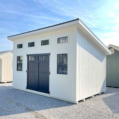 a white building with two black doors and windows