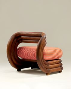 an orange and white striped chair sitting on top of a wooden frame with a cushion