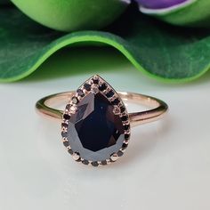 a close up of a ring on a table with flowers in the background and green leaves