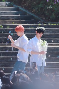 two young men standing next to each other in front of some stairs with soap bubbles