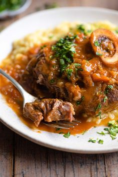 a close up of a plate of food with meat and gravy on it