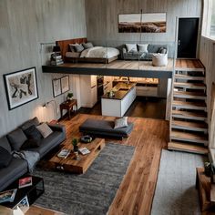 a living room filled with furniture next to a stair case and wooden floored walls