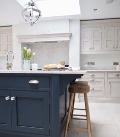 a kitchen island with two stools in front of it and an open skylight