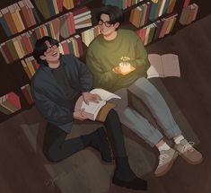 two people sitting on the floor in front of bookshelves with a lit candle