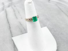 This emerald and diamond ring is classic, yet dazzling! The emerald is hypnotic and dreamy, with an iconic green hue that can't help but draw your eye. Bright and sparkling diamonds cascade down the shoulders of the ring, creating a gorgeous play of light. Metal: Platinum (Head), 14K Yellow Gold Gem: Emerald .94 Carats Gem Measurements: 4.6 x 6.4 mm, Emerald Cut Accents: 6 Diamonds totaling .42 Carats, SI in Clarity, H in Color Ring Size: 4.25 Marks: "88 14K" Stamped on the inside band Green Emerald Ring With Diamond Accents, Green Emerald Diamond Ring With Accents, Emerald Cut Green Diamond Ring With Diamond Accents, Green Diamond Ring With Vvs Clarity, Fine Green Diamond Ring With Vvs Clarity, Emerald Cut Green Diamond Ring With Accents, Classic Green Emerald Ring With Diamond Accents, Green Diamond Ring With Vvs Clarity For May Birthstone, Green Diamond Solitaire Ring