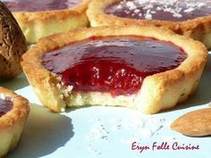 several small pastries with jam in them on a table