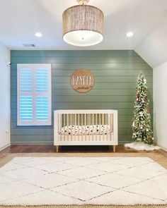 a baby's room with a crib and christmas tree