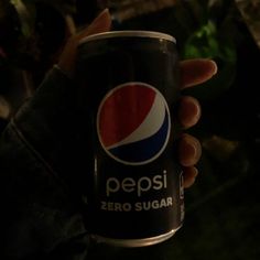 a person holding a can of pepsi in their hand