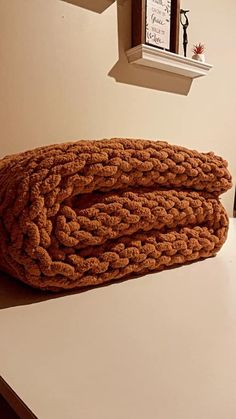 a pile of brown blankets sitting on top of a white counter next to a clock