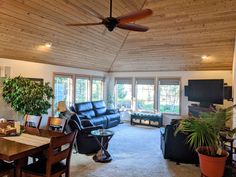 a living room filled with furniture and a flat screen tv on top of a wooden ceiling