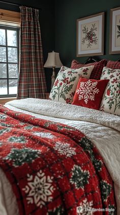 a bedroom decorated in red and green with snowflakes on the bed, two framed pictures above