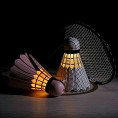 a lamp that is sitting on top of a table next to a badminton racket