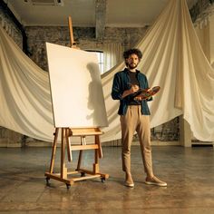 a man is standing in front of an easel