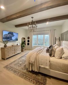 a large bed sitting in a bedroom next to a tv on top of a dresser