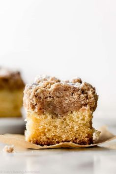 a piece of cake sitting on top of a white plate next to a cupcake