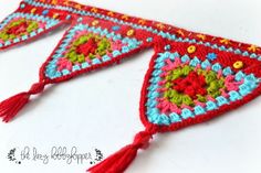 two crocheted pennants with tassels and beads on them, one is red