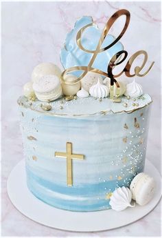 a blue cake with gold lettering and seashells on top