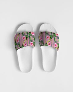 a pair of white slippers with green and pink flowers on the bottom, against a white background