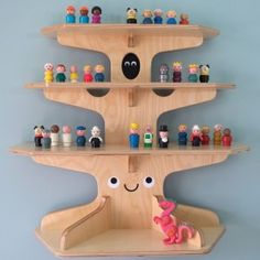 a wooden shelf filled with lots of toy figurines on top of each other