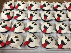 the cupcakes are decorated with white frosting and black icing, which have red noses