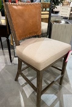 a chair that is on display in a room with other chairs and tables behind it