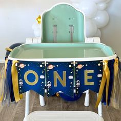 a baby's first birthday party with a one sign on the table and balloons in the background