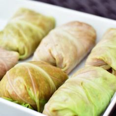 some food that is in a white dish on a black table and it looks like lettuce