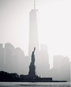 the statue of liberty is surrounded by tall buildings