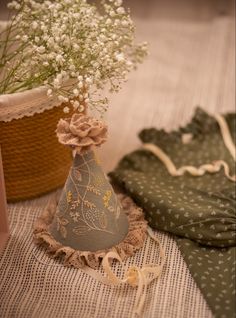 a vase with baby's breath flowers in it sitting next to a cloth bag