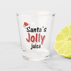 a shot glass with santa's jolly juice next to a lemon