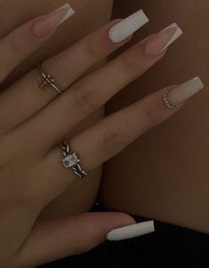 a woman's hands with white nails and rings