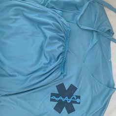 an image of the back of a blue shirt with black and blue medical symbols on it