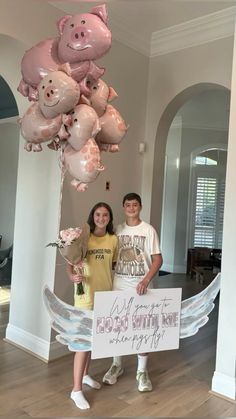 two people standing next to each other holding balloons