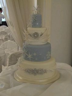 a three tiered wedding cake with snowflakes on it