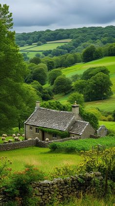 a small house in the middle of a lush green field with sheep grazing on it