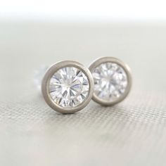 4 mm moissanite stud earrings, bezel set in 14k yellow, rose or white gold, or sterling silver. 14k white gold is pictured except for 6th photo which shows sterling silver. These earrings are made to order and will ship within 3-5 days. DETAILS - 4 mm moissanite - bezel setting - satin finish - solid 14k gold or sterling silver - white gold contains nickel, not rhodium plated - sold sterling silver or 14k gold backs - made to order within 3-5 days What is Moissanite? Moissanite is lab created si Classic Jewelry With Bezel Set Round Stone, Classic Jewelry With Bezel-set Round Stone, Modern White Gold Earrings With Bezel Setting, 14k White Gold Jewelry With Bezel Setting, Everyday White Gold Jewelry With Bezel Setting, Everyday Moissanite Jewelry, Classic Everyday Jewelry With Tension Setting, Hypoallergenic Round Cut Jewelry For Anniversary, Modern 14k White Gold Jewelry With Bezel Setting