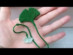 a hand is holding a green string with an elephant on it