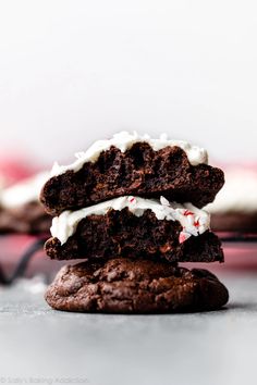 two chocolate cookies with white frosting stacked on top of each other