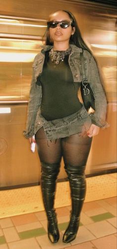 a woman in tights and boots is posing for the camera with her hands on her hips