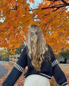 a woman standing under a tree with her back to the camera