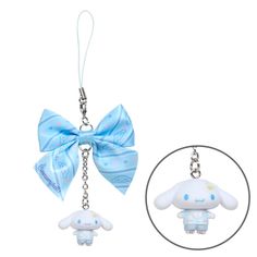 a keychain with a blue bow on it and a white stuffed animal hanging from the front